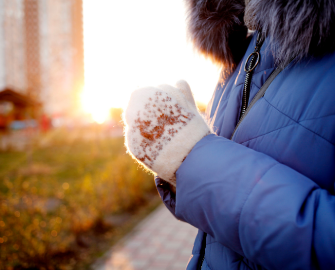 Woman looks at water on a store shelf.